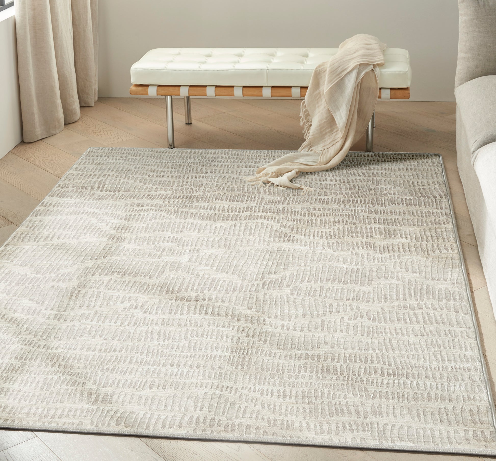 Neutral ivory-gray textured area rug with a subtle wavy pattern; modern living-room essential.