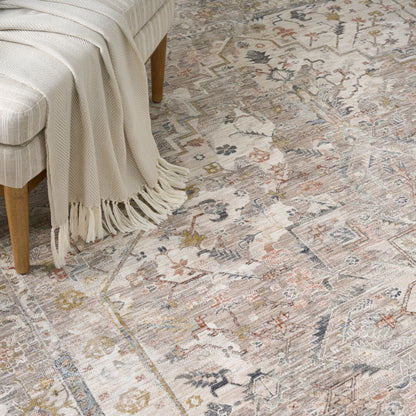 Cream knit throw with fringe draped over a light-wood chair on a muted vintage floral rug (5' x 8').