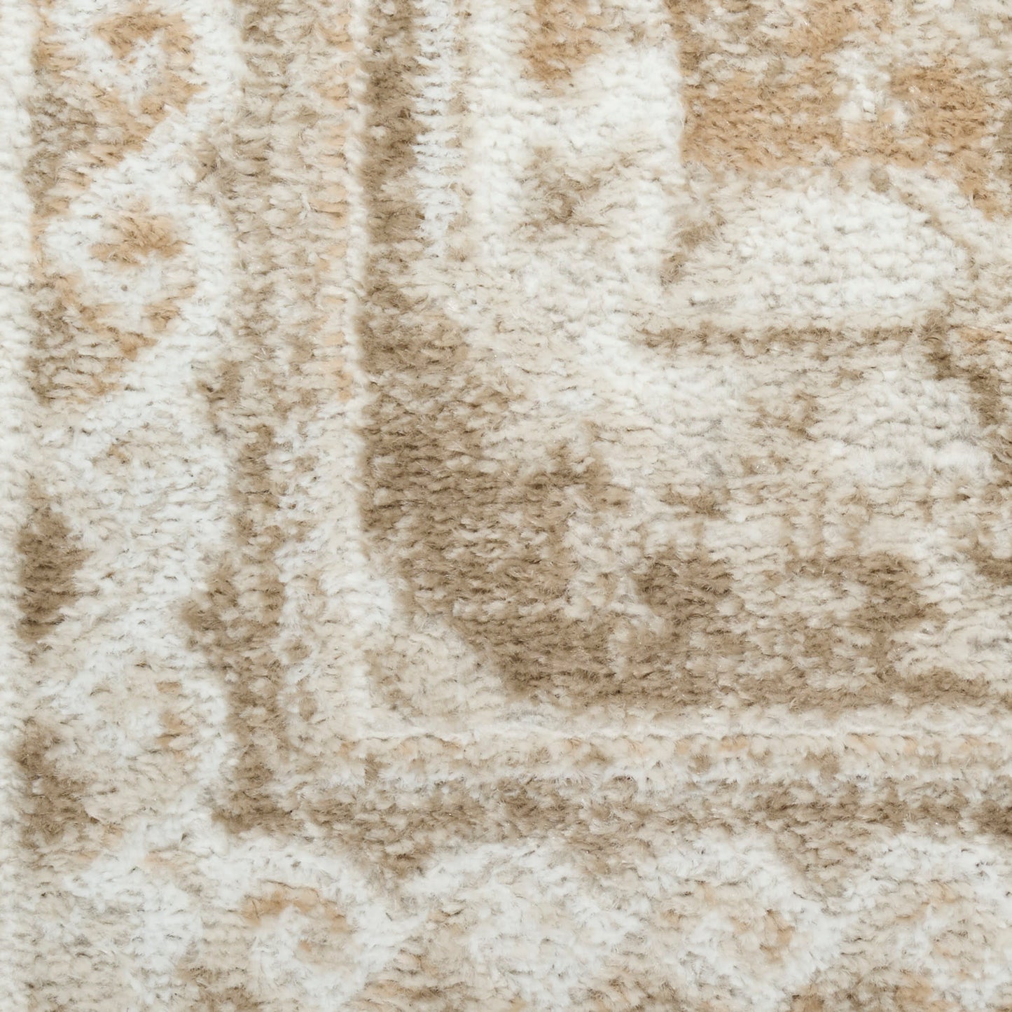 Close-up of beige and cream shag rug with plush pile and subtle geometric border.