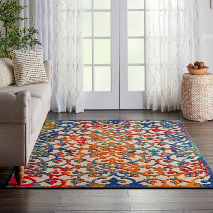 Vibrant multicolor woven area rug with interlaced floral pattern in red, blue, orange and yellow on a dark wood floor.