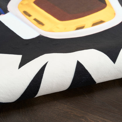Close-up of a folded soft rug with a bold black-and-white graphic and a yellow accent, round 5' rug.