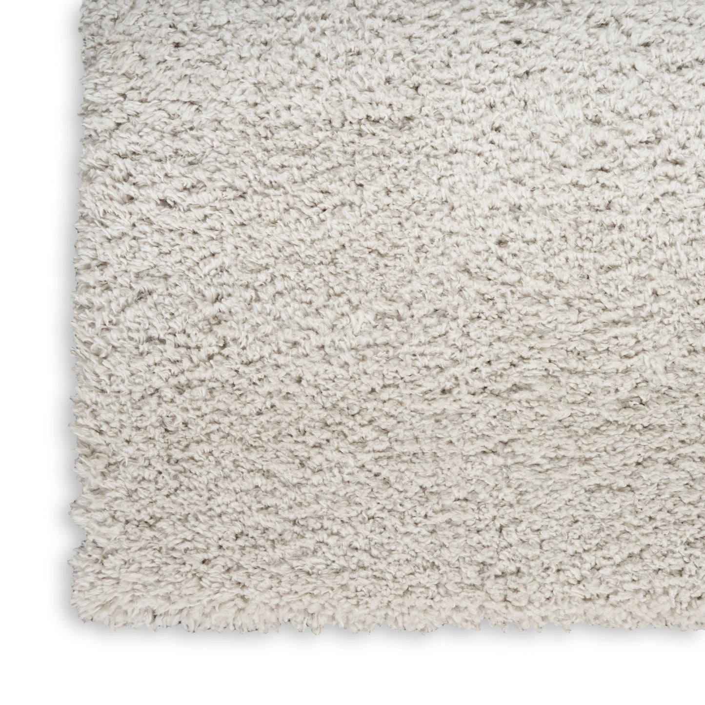 Beige shag rug corner close-up showing dense fluffy pile and soft faux wool texture.