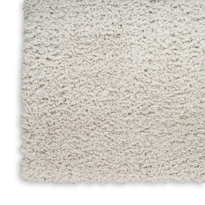 Beige shag rug corner close-up showing dense fluffy pile and soft faux wool texture.