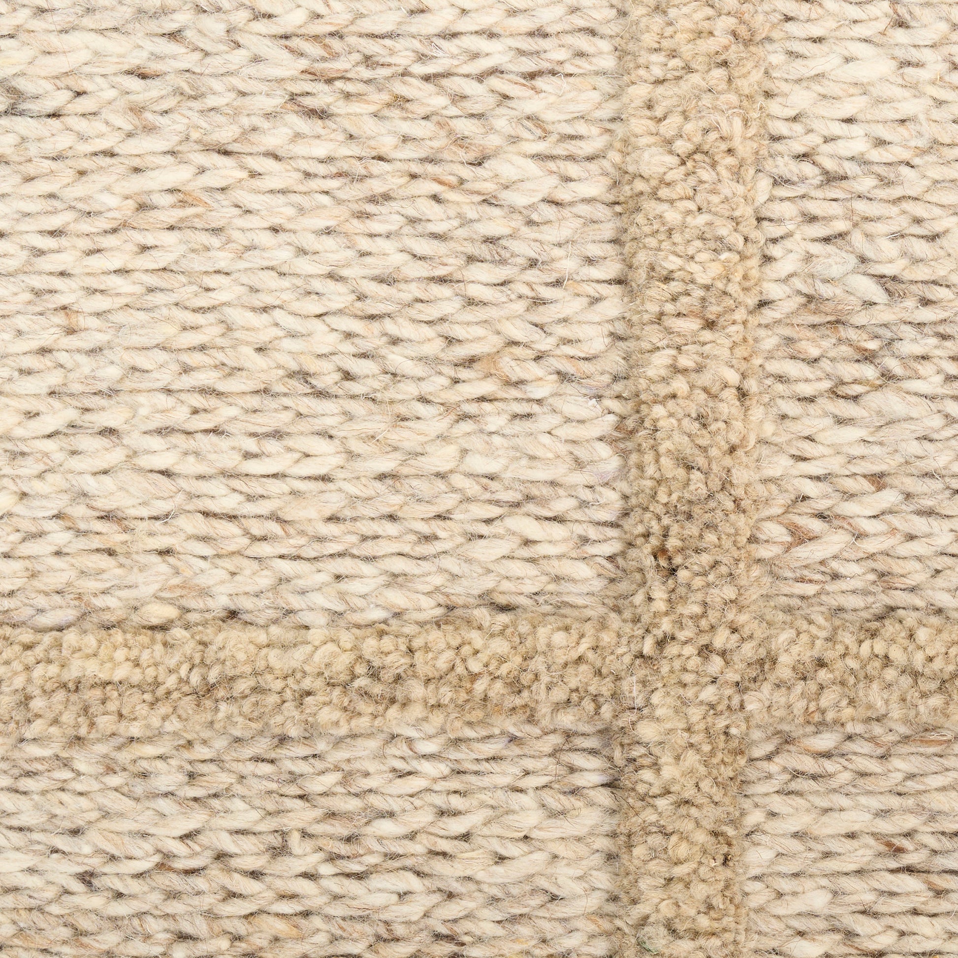Natural beige chunky woven rug with thick border seam and rope-like fibers.