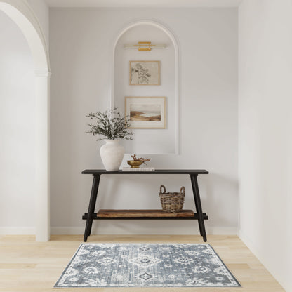 Dark wood console with lower shelf, white vase with branches, woven basket, arched wall niche with framed art, blue patterned rug.