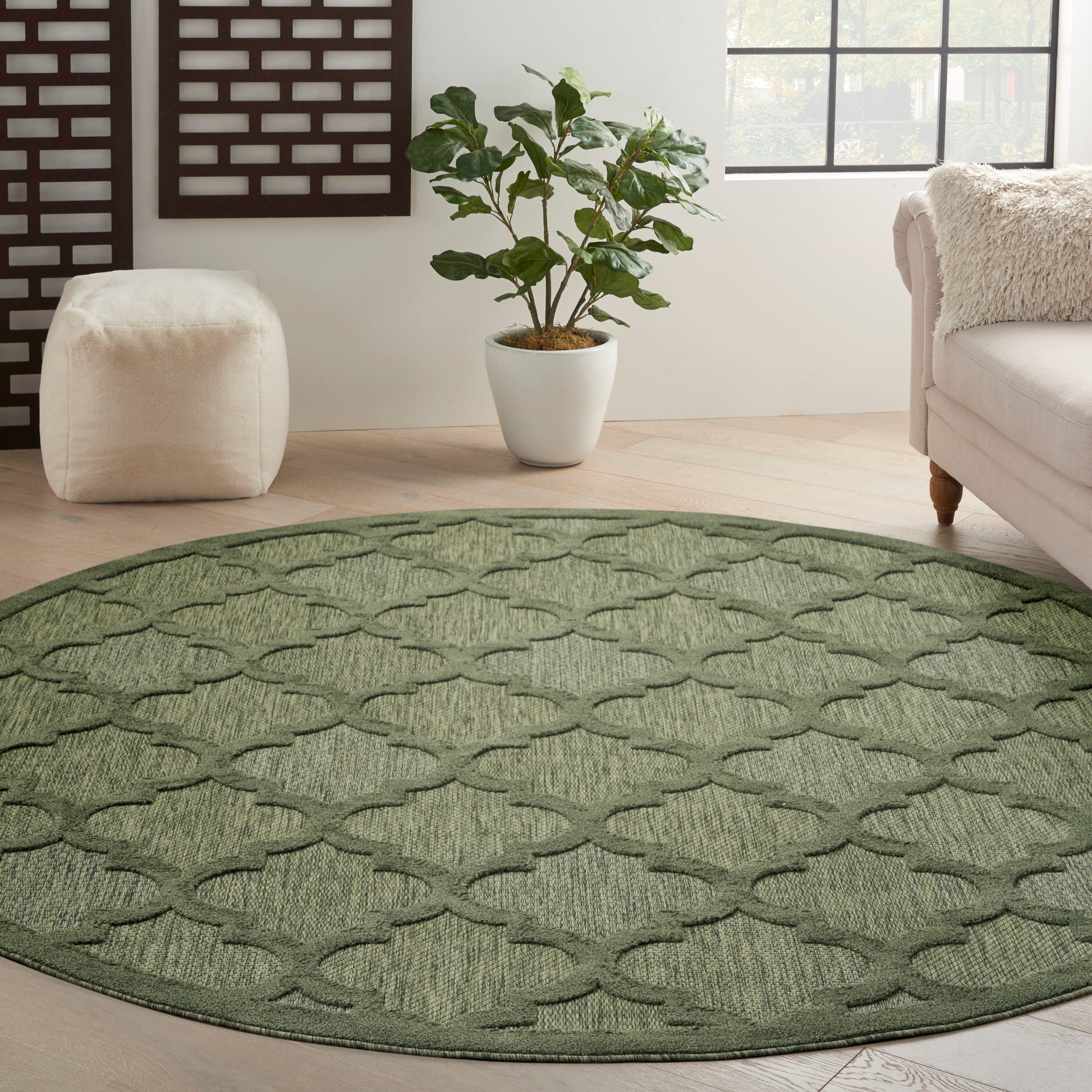 Round olive-green woven rug with a lattice pattern in a modern living room.