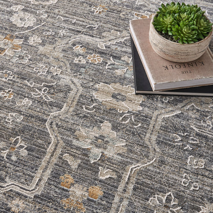 Gray oriental rug with ivory floral motifs; ceramic pot with succulent on stacked books.