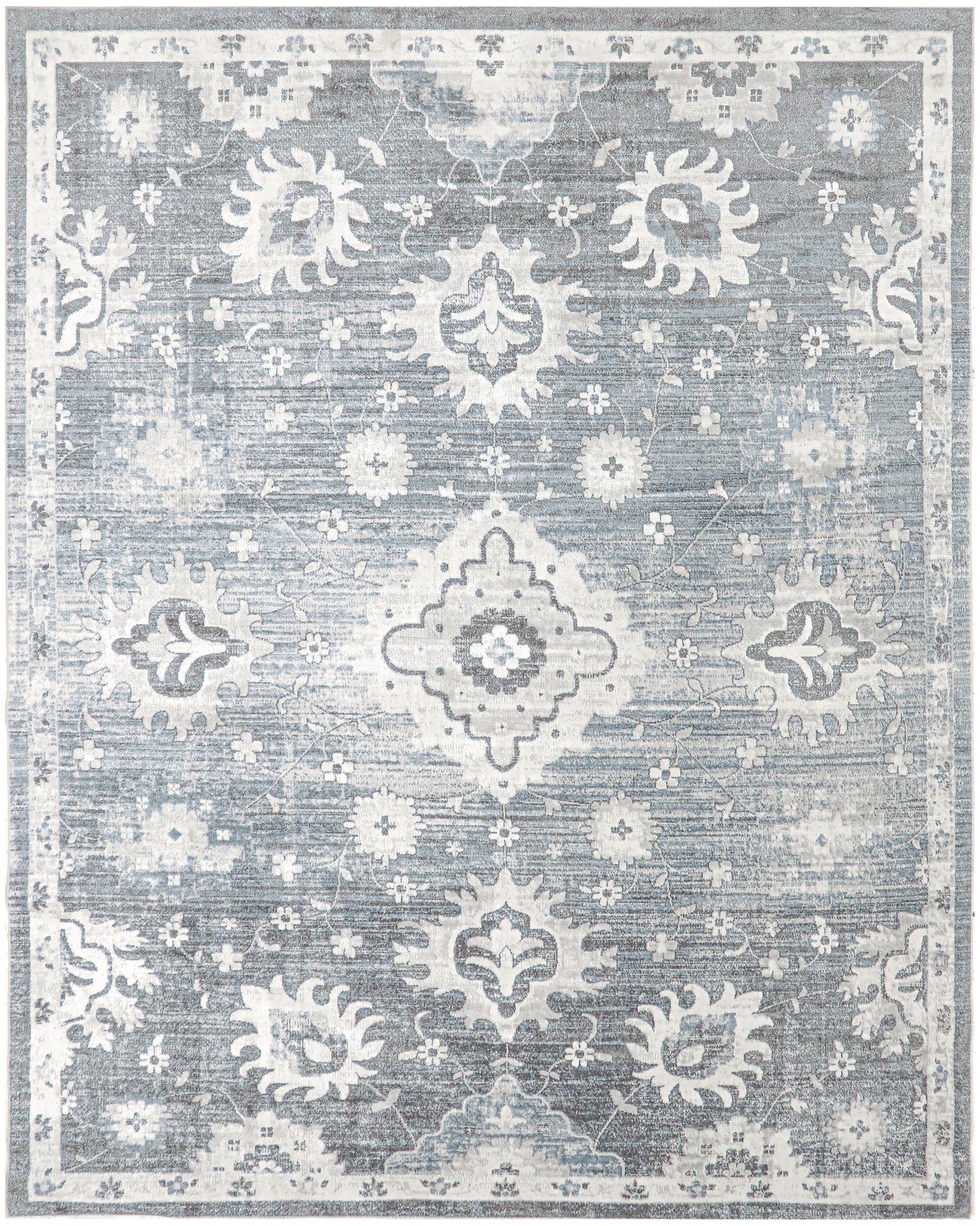 Blue-gray distressed oriental rug with white floral medallions and ornate border, vintage-inspired living room decor.