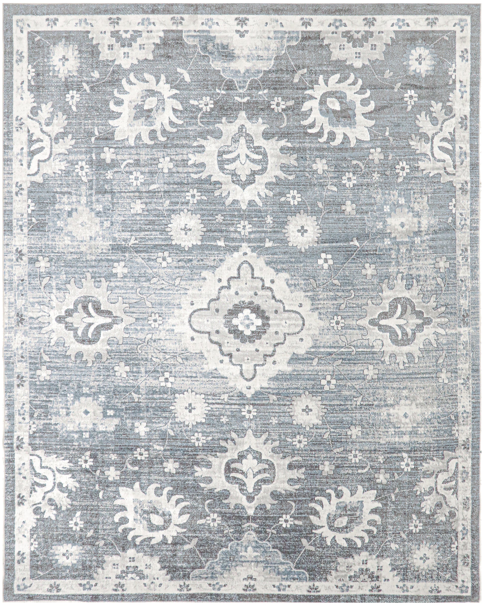 Blue-gray distressed oriental rug with white floral medallions and ornate border, vintage-inspired living room decor.