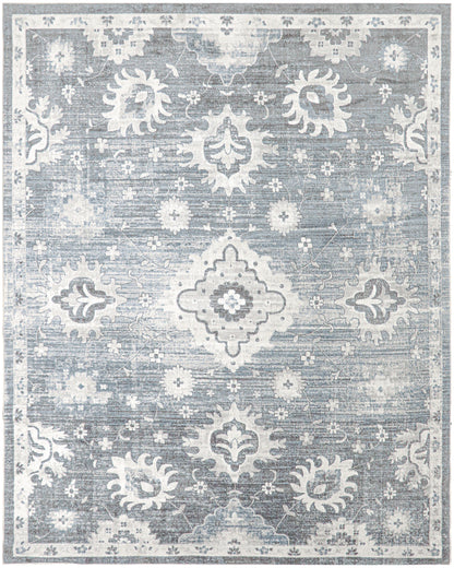 Blue-gray distressed oriental rug with white floral medallions and ornate border, vintage-inspired living room decor.