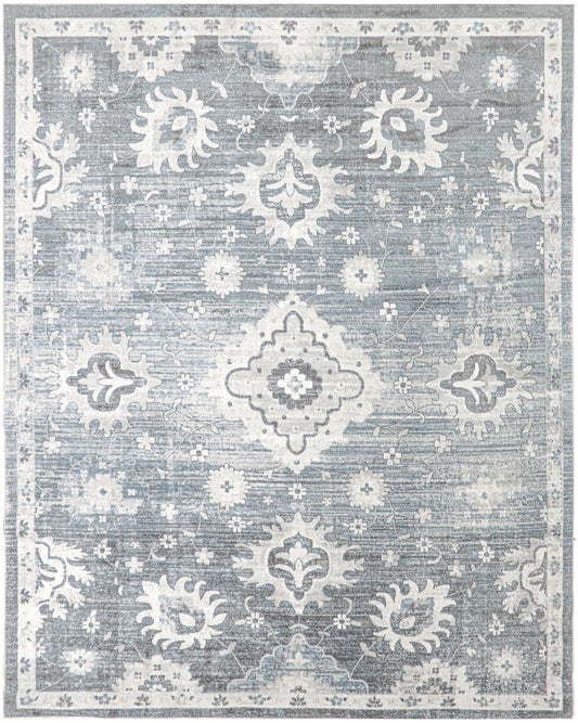 Blue-gray distressed oriental rug with white floral medallions and ornate border, vintage-inspired living room decor.