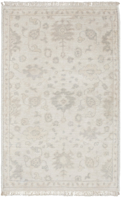 Cream Persian-style area rug with pale grey floral medallion pattern and fringed edges.