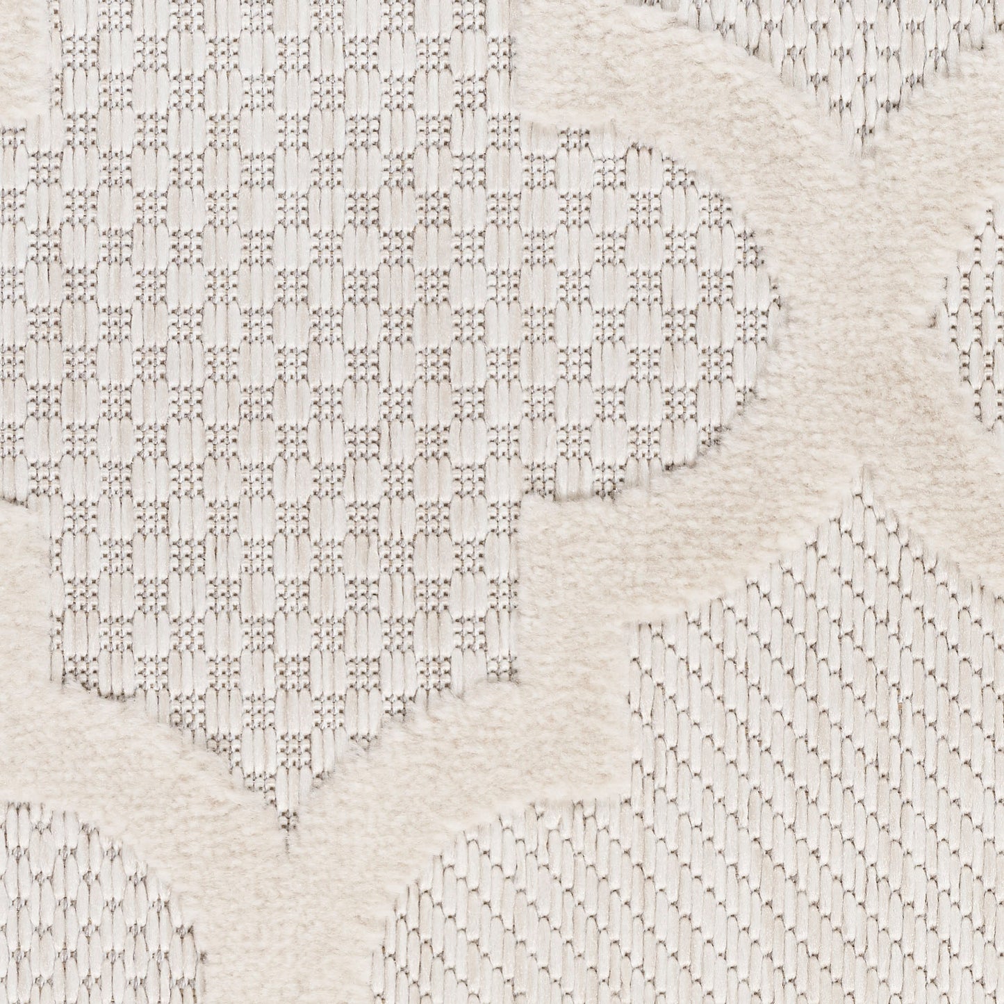 Cream textured fabric with raised plush motifs and geometric lattice pattern, soft woven decor rug.