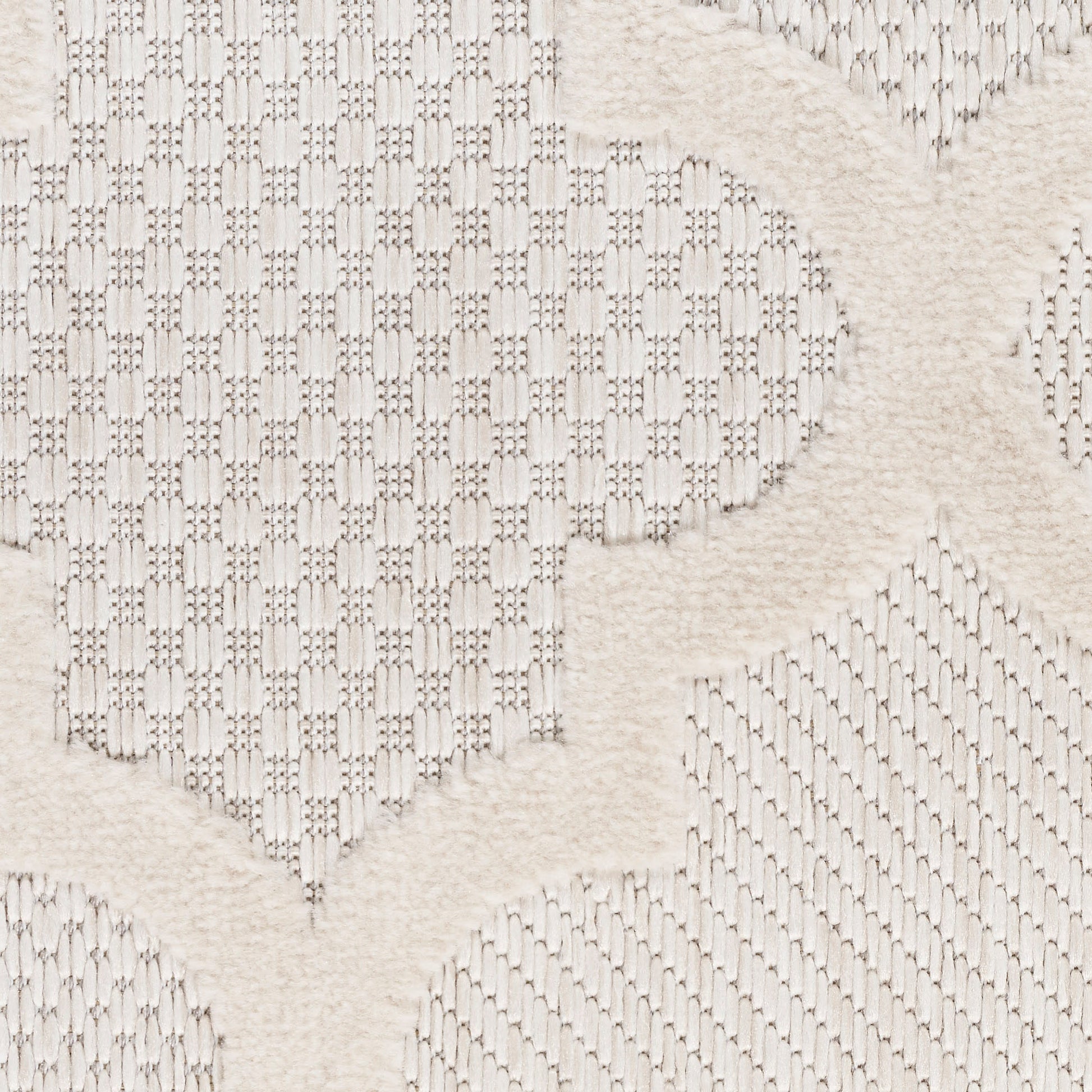 Cream textured fabric with raised plush motifs and geometric lattice pattern, soft woven decor rug.