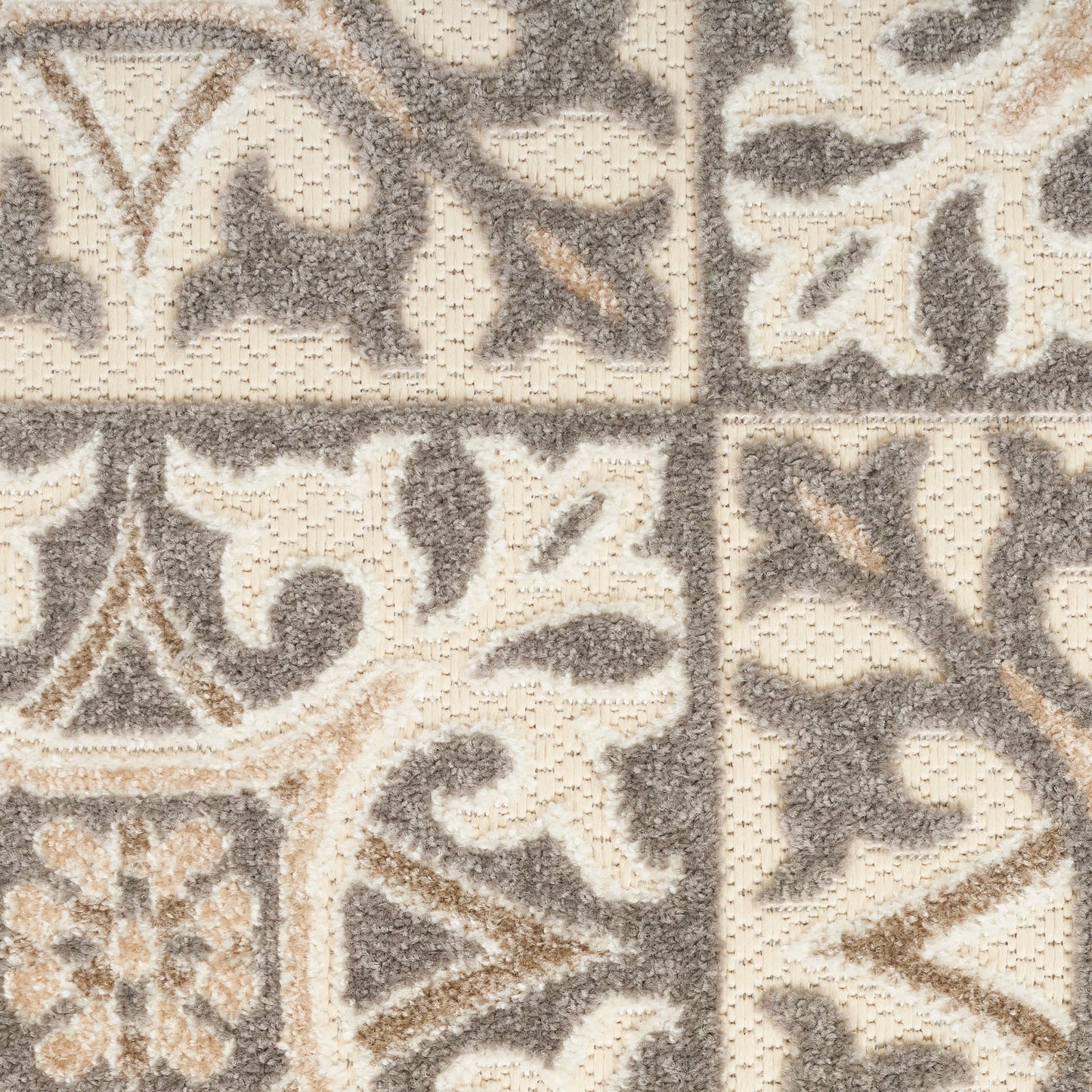 Beige and gray tufted rug with damask floral motifs in a tiled square pattern.