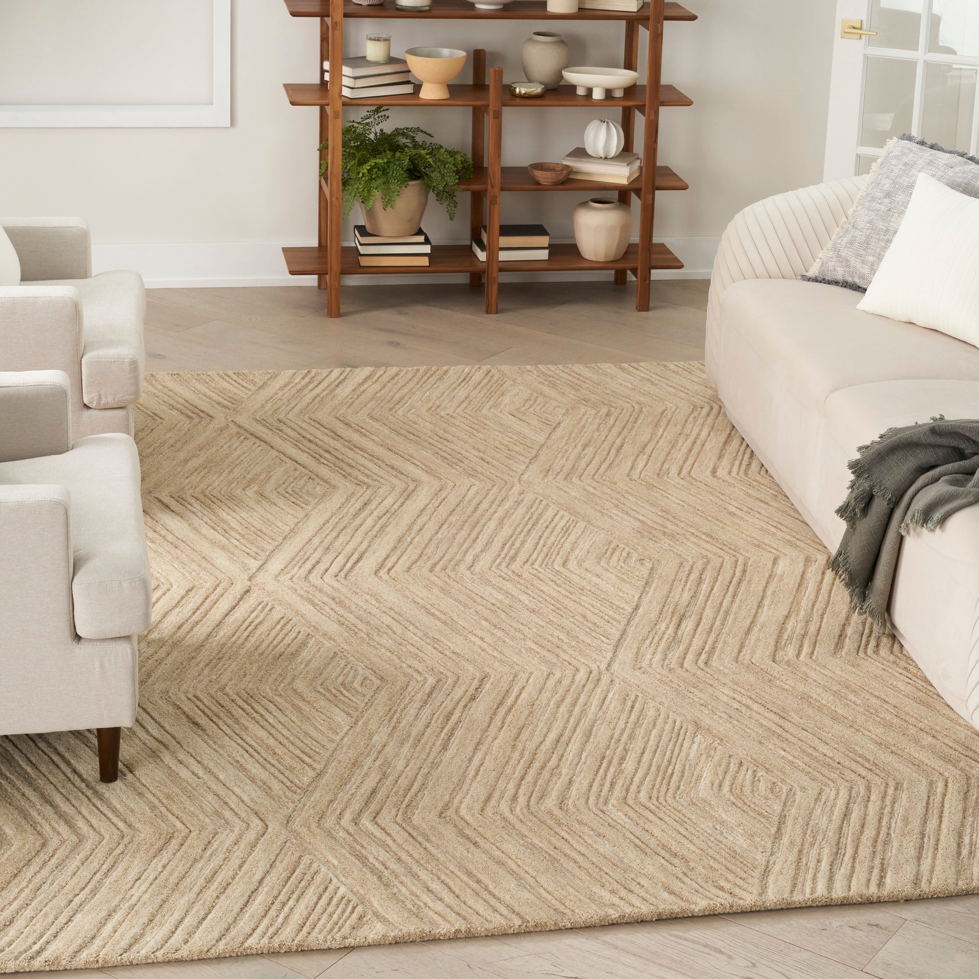 Natural jute rug with a beige chevron geometric pattern in a neutral modern living room.