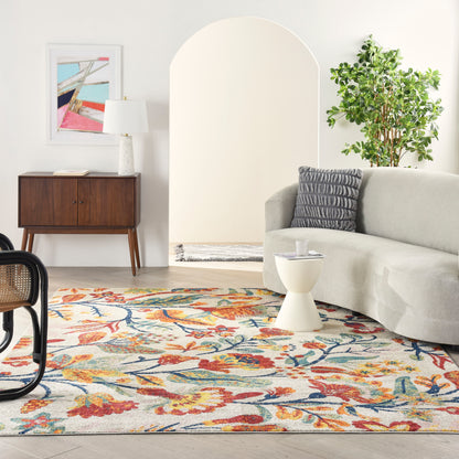 Cozy contemporary living room with floral rug, gray sofa, white coffee table, wooden console, abstract art, and a plant.