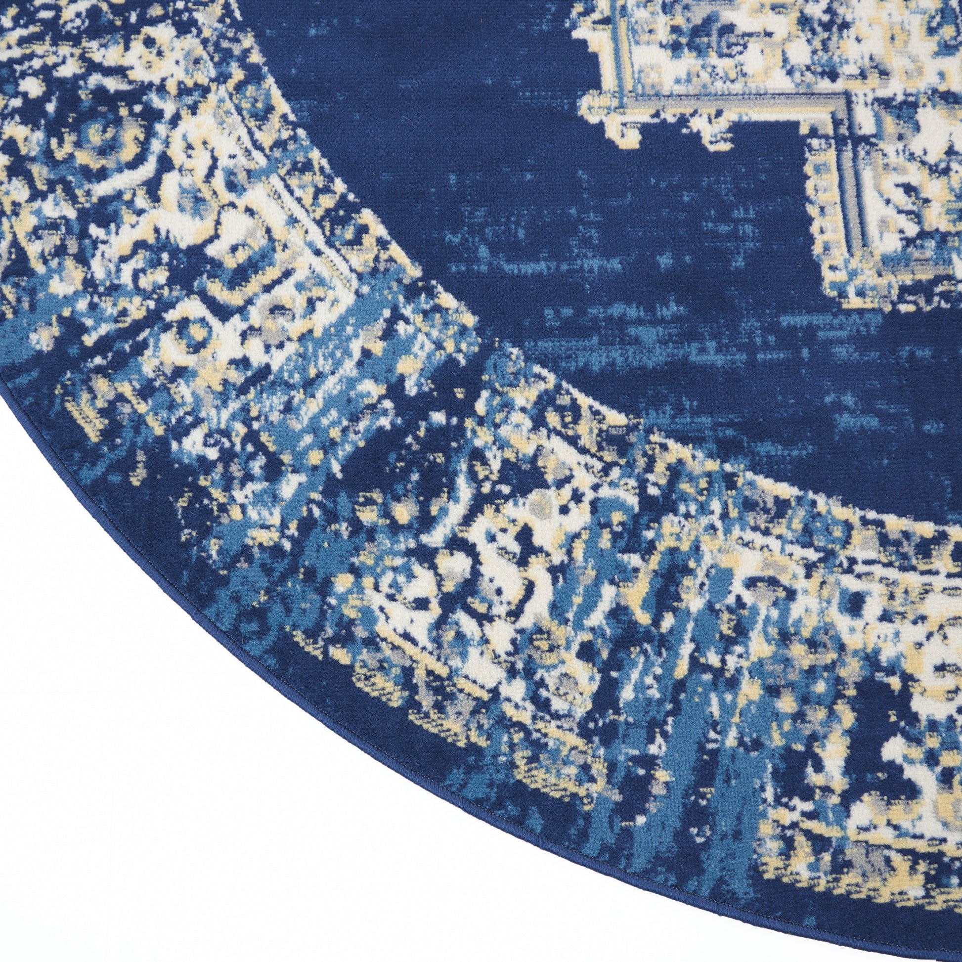 Round navy rug with ornate cream and gold border, Persian-inspired pattern, plush texture.