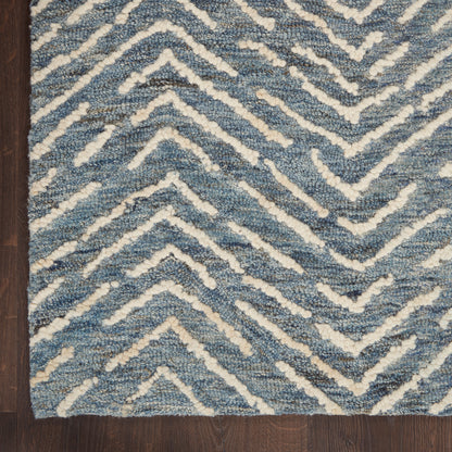 Blue and white chevron shag rug with plush texture on dark wood floor.