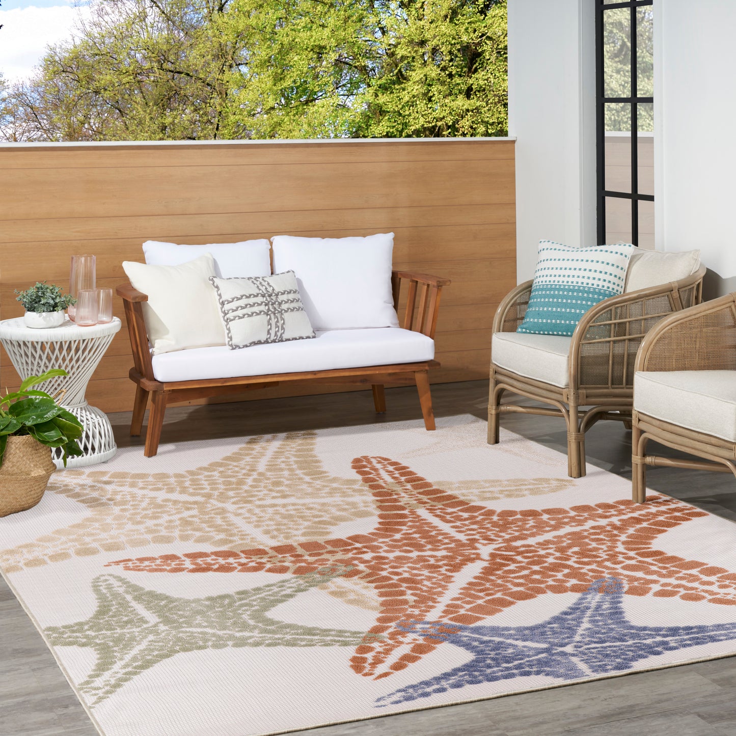 Outdoor rug with multicolor starfish pattern on beige.