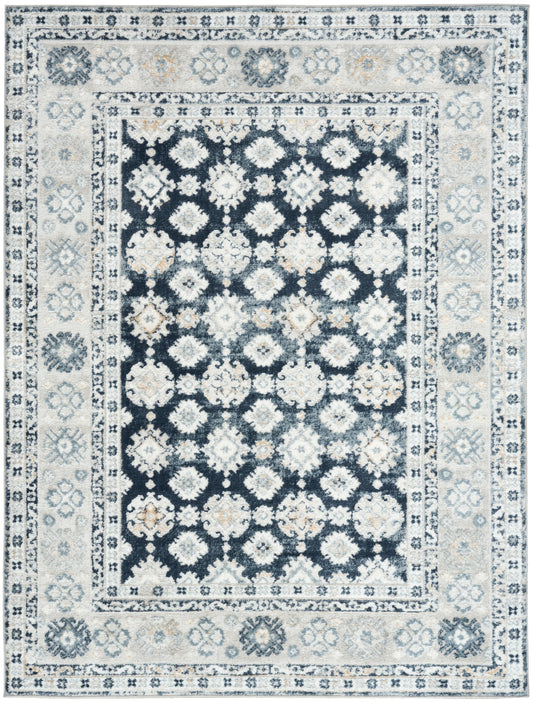 Rectangular oriental rug with a dark navy center and white floral medallions, surrounded by ivory and light blue borders.