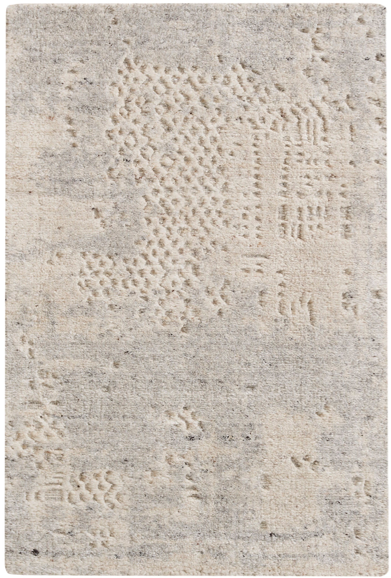 Beige textured area rug with abstract patchwork patterns in cream and taupe tones.