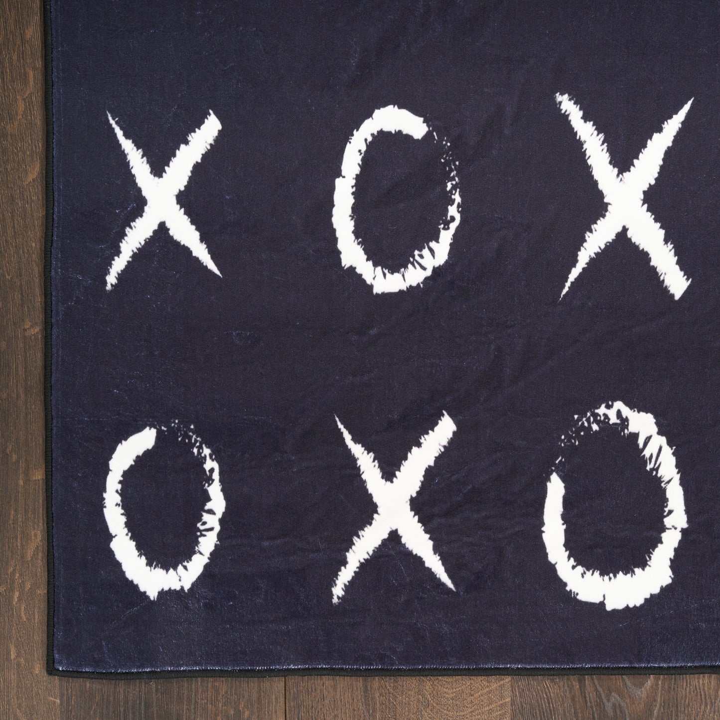 Dark navy rug with large white chalky X and O marks in a tic-tac-toe layout.