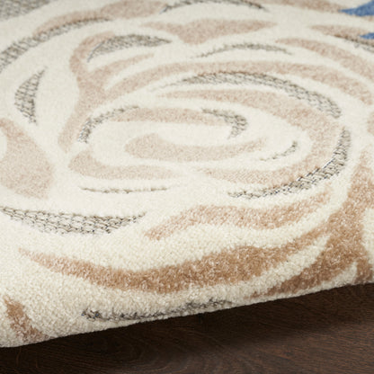 Close-up of a plush tufted area rug with cream, beige & tan swirl pattern on a dark wooden floor.