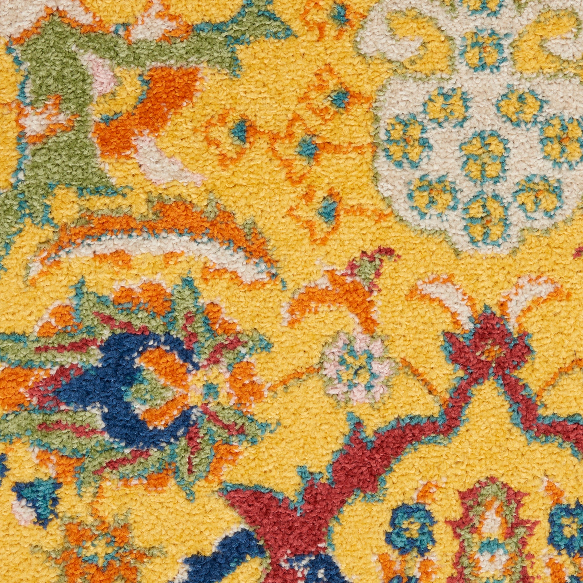 Close-up of a yellow tufted pile rug featuring multicolor floral motifs in blue, orange, green and red.