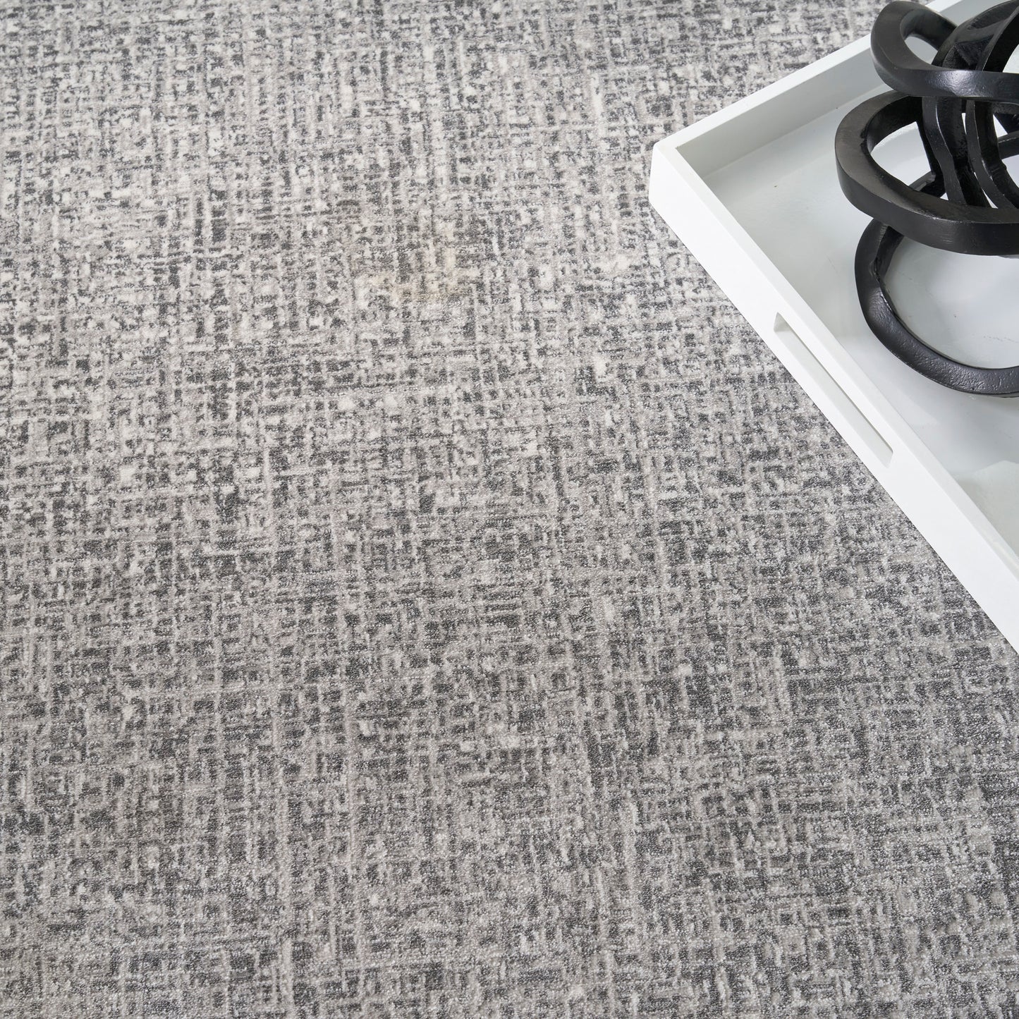 Gray textured rug with a white rectangular tray and black circular burner coils on top.