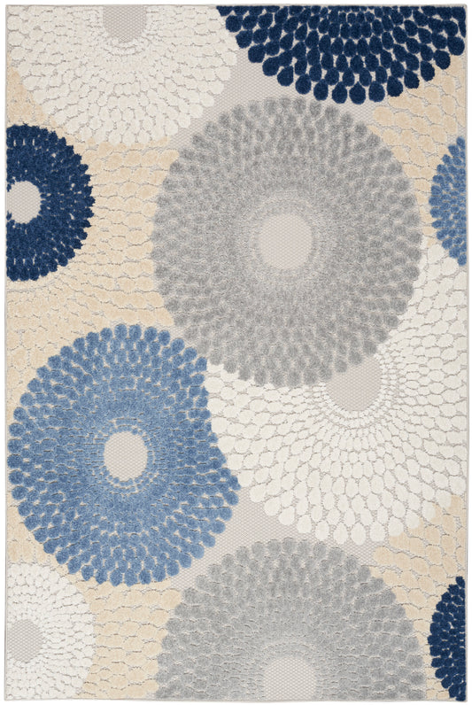 Tufted area rug with large circular floral patterns in navy, blue, gray and beige on a light background; textured modern design.