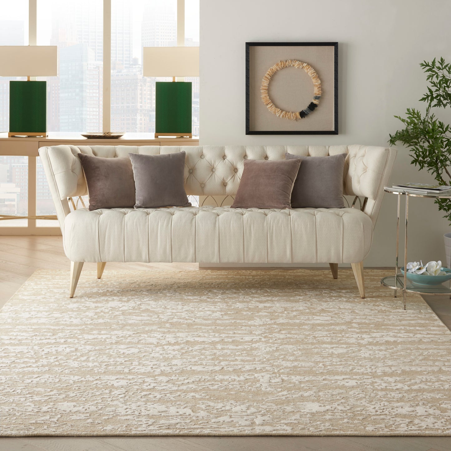 Cream rug in a bright city living room with rope art and green lamps.