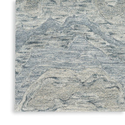 Abstract blue and beige rug with textured pile; mountain-like pattern and soft woven feel.