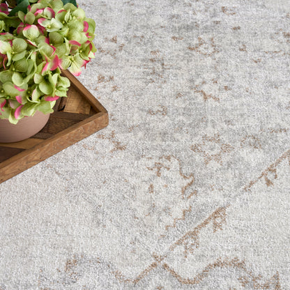 Green hydrangea with pink-tinged blooms in a pink pot on a wooden tray atop a light gray patterned rug