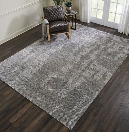 Large rectangular gray textured rug on dark wood floor; brown quilted leather armchair in a modern cozy living space.