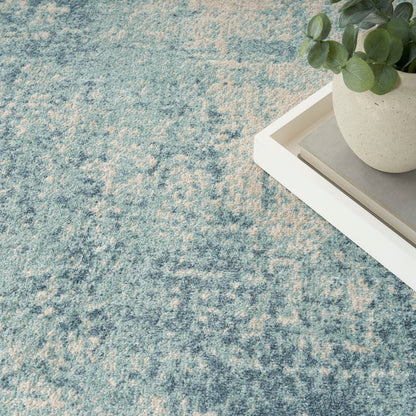 Blue and cream mottled rug with a white tray and potted eucalyptus on the top right.
