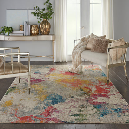 Gold metal-framed chairs, cream sofa, plush fur throw, and a multicolor abstract rug with red, yellow, teal accents.