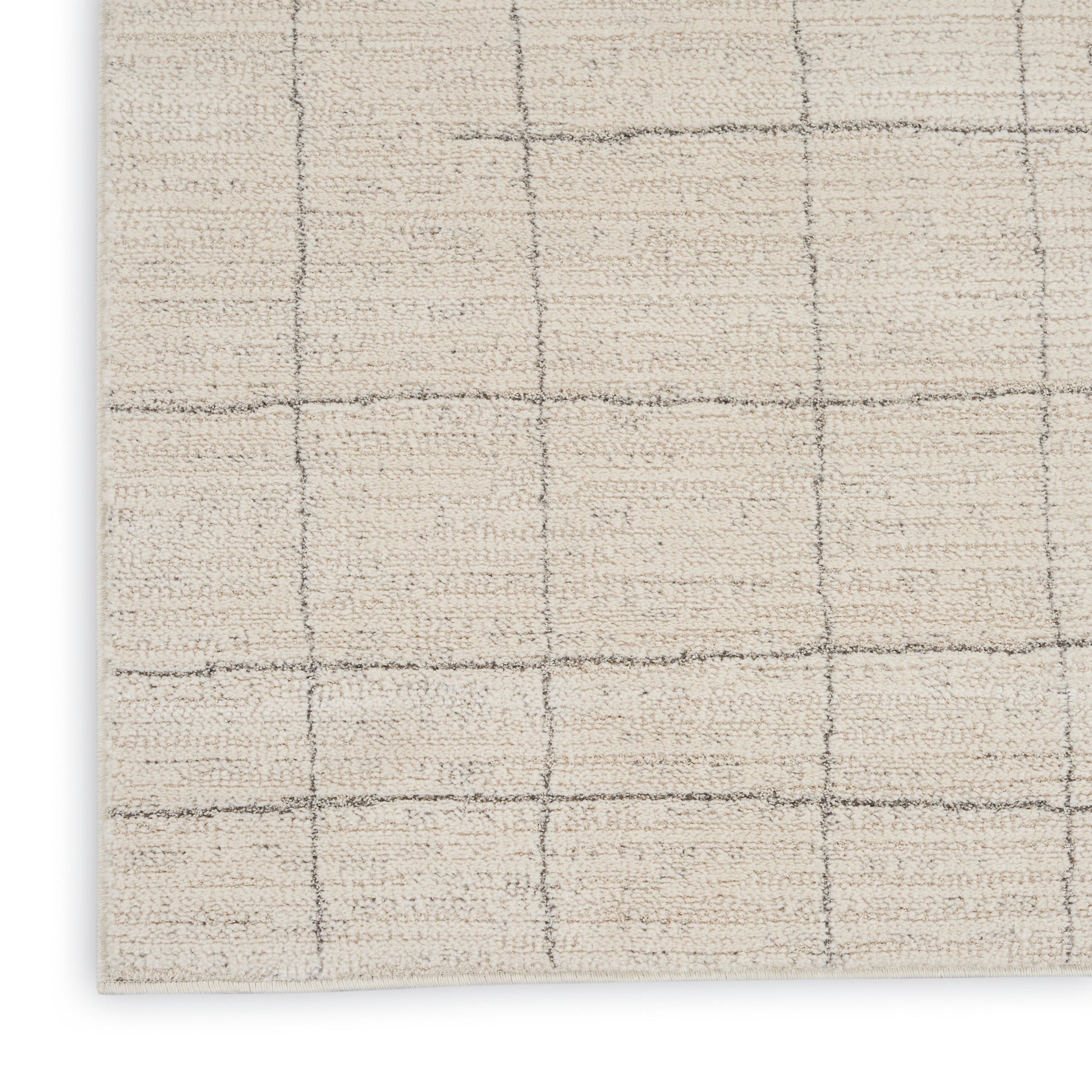 Beige textured area rug with subtle gray grid lines forming square blocks; close-up corner view.