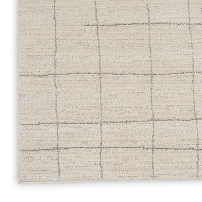 Beige textured area rug with subtle gray grid lines forming square blocks; close-up corner view.