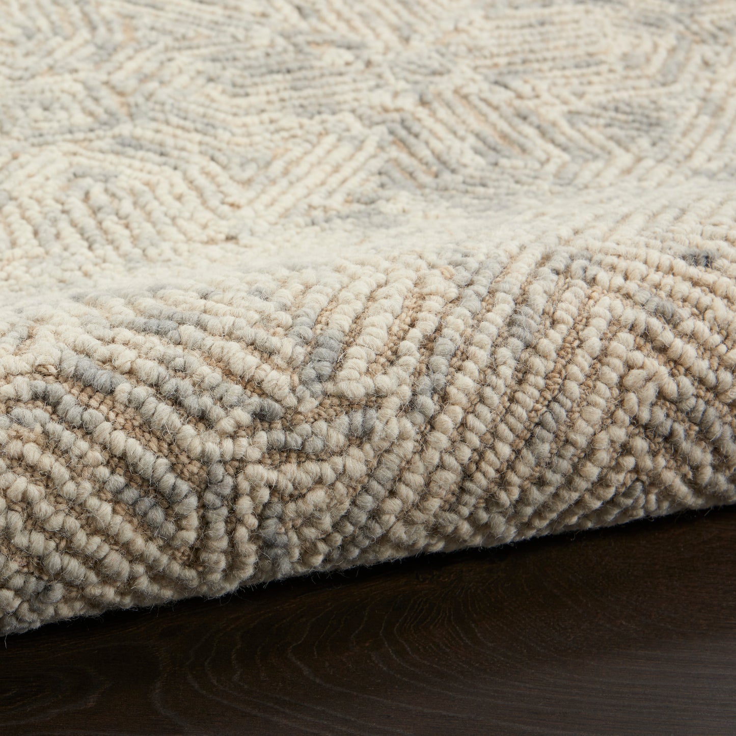 Beige cream boucle rug with soft dense looped pile and subtle geometric chevron pattern.