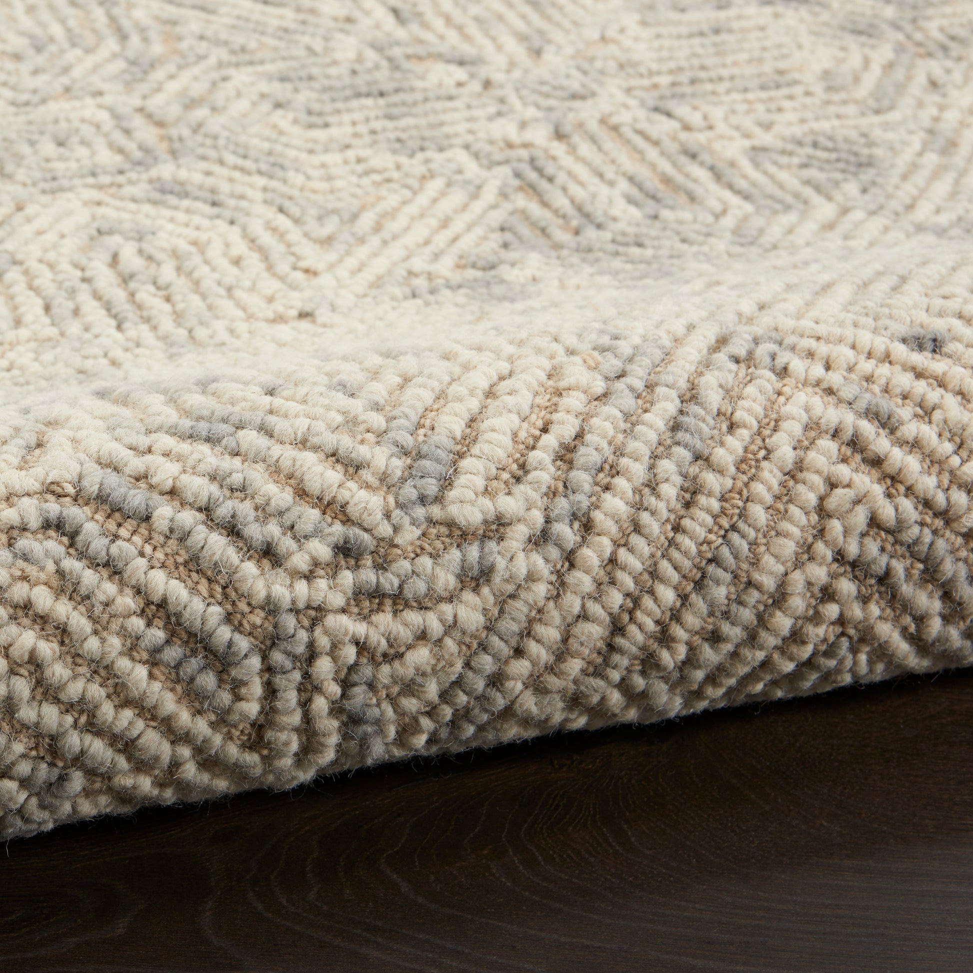 Beige cream boucle rug with soft dense looped pile and subtle geometric chevron pattern.