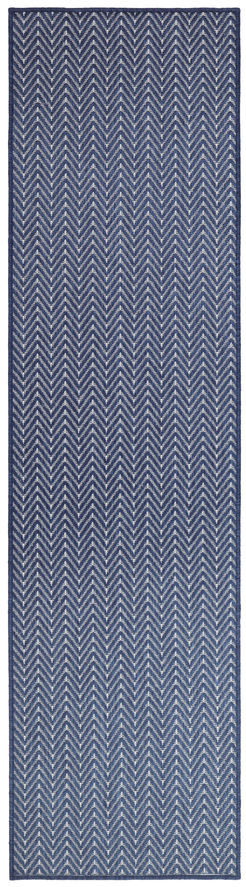 Navy blue woven runner rug with white chevron zigzag pattern and blue border.