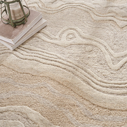 Beige textured rug with raised wavy lines; plush pile, cozy home decor vibe, lantern and books decorating corner.