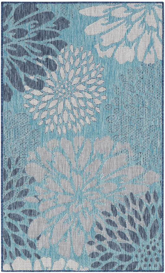 Teal-blue area rug with oversized white and light-blue floral motifs in a textured weave.