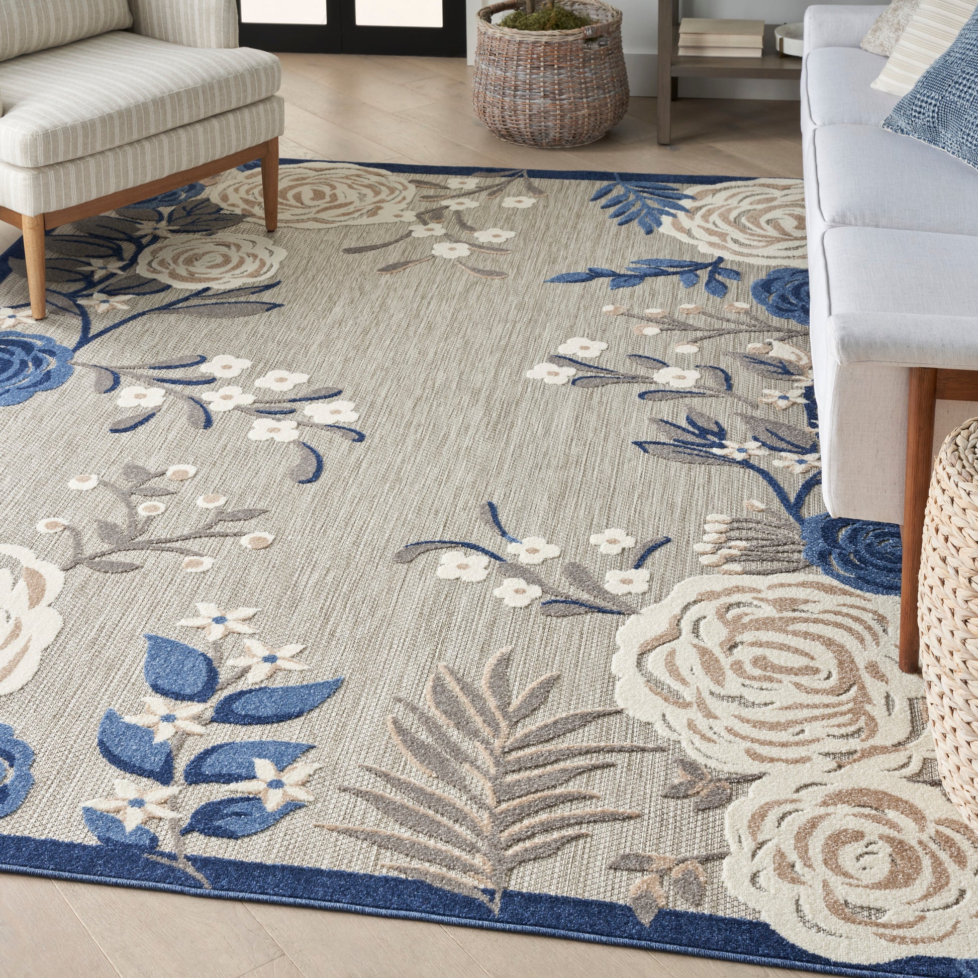 Beige floral area rug with blue and white blossoms and blue border; soft woven texture for living room.