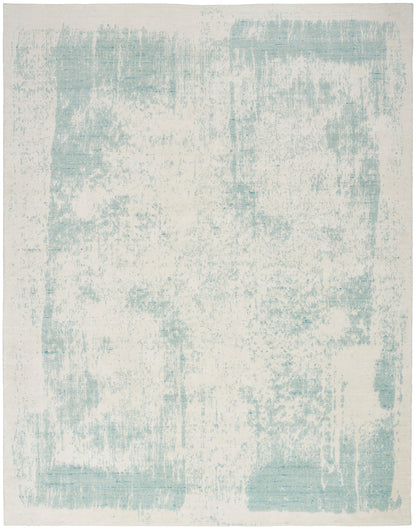 Rectangular area rug with cream base and pale blue distressed abstract pattern; modern, neutral decor.