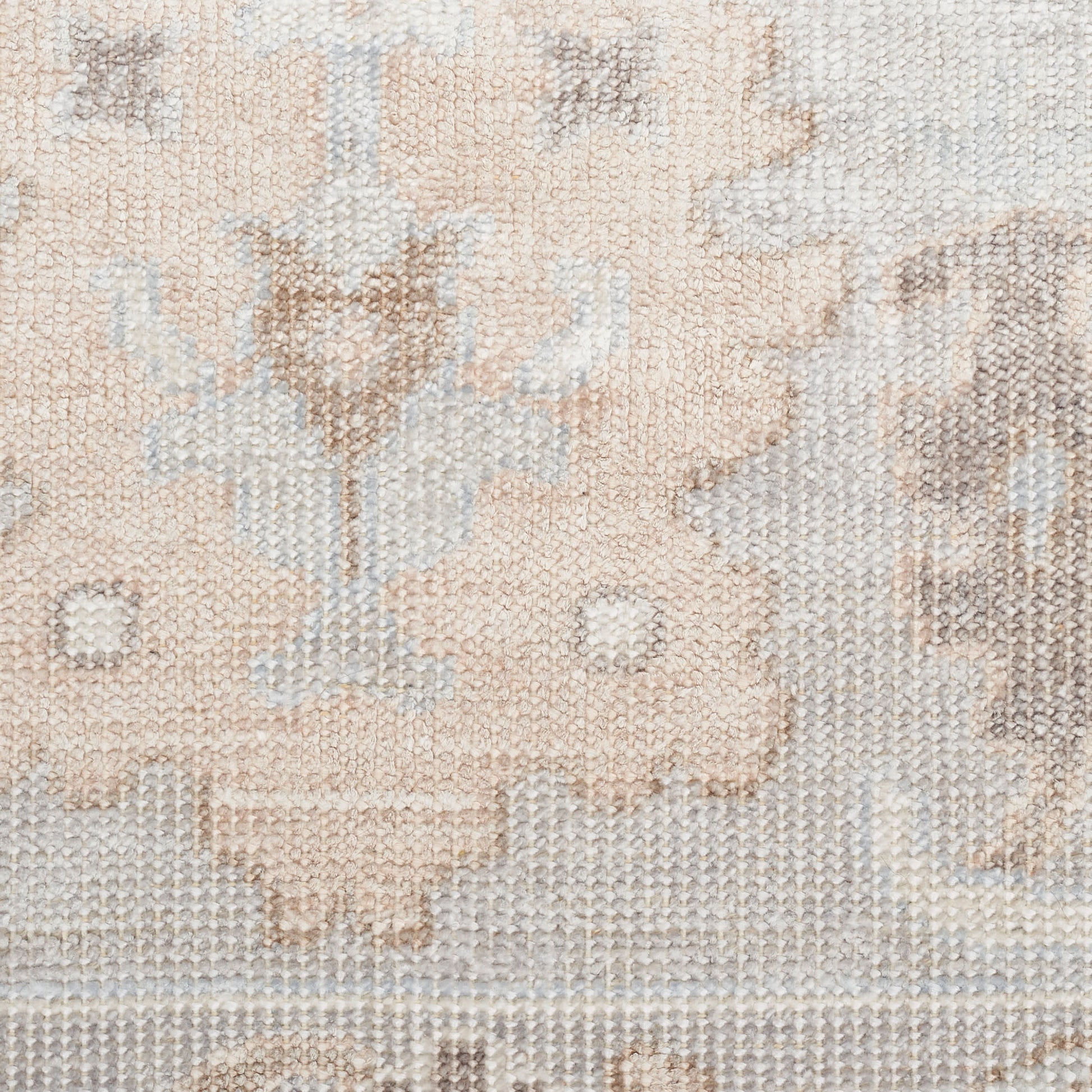 Close-up of a beige cream oriental rug with subtle floral motifs and woven texture.