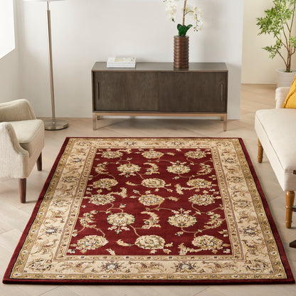 Deep burgundy oriental rug with cream floral motif and ornate beige border in a modern living room.