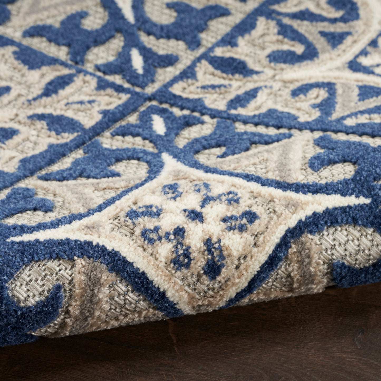 Soft blue and beige Persian-style area rug with ornate scroll pattern and plush cut-pile.