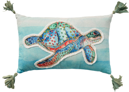Rectangular throw pillow with gradient blue background and a colorful turtle patchwork applique; tasseled corners.